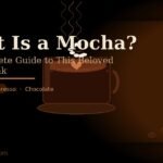 **A steaming mocha coffee cup with latte art, whipped cream, and chocolate drizzle on a dark espresso-toned background with the text "What Is a Mocha?"**
